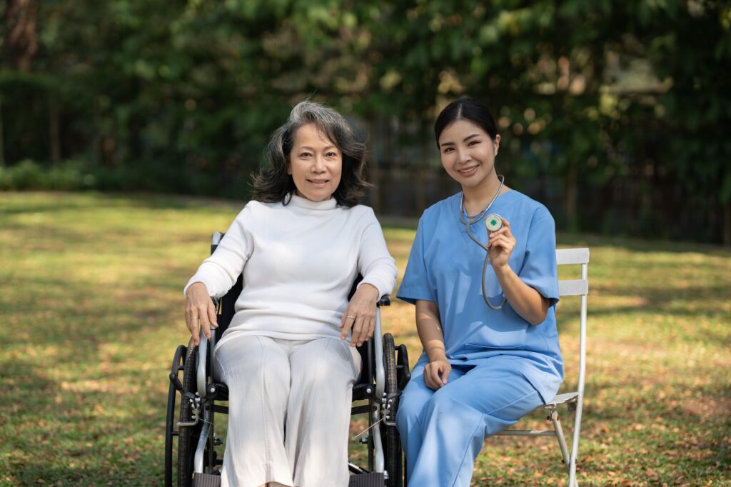 Caregiver with elderly woman doing weekly check-ups at the patient's residence garden.